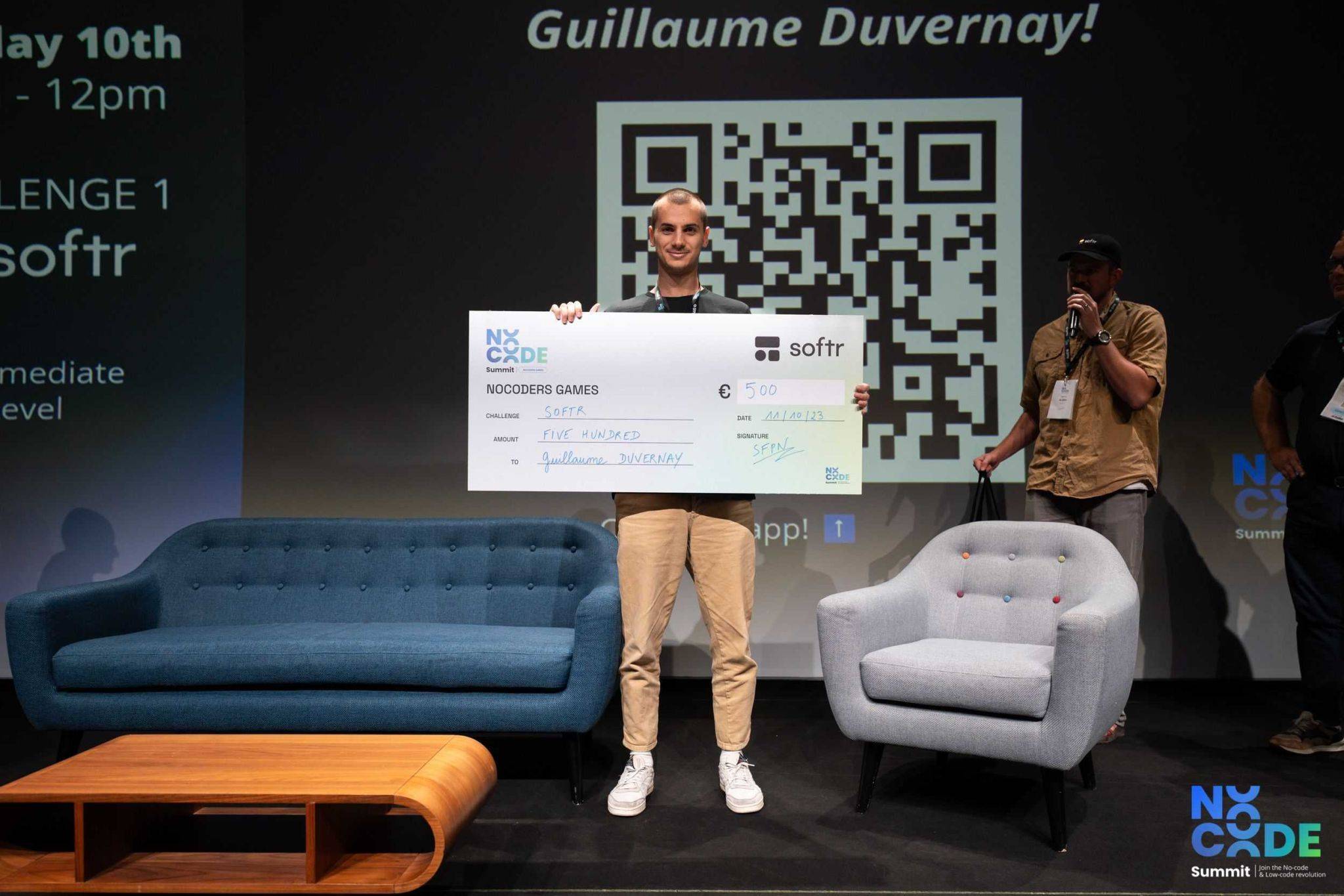 Guillaume en el escenario con el cheque del premio del desafío Softr