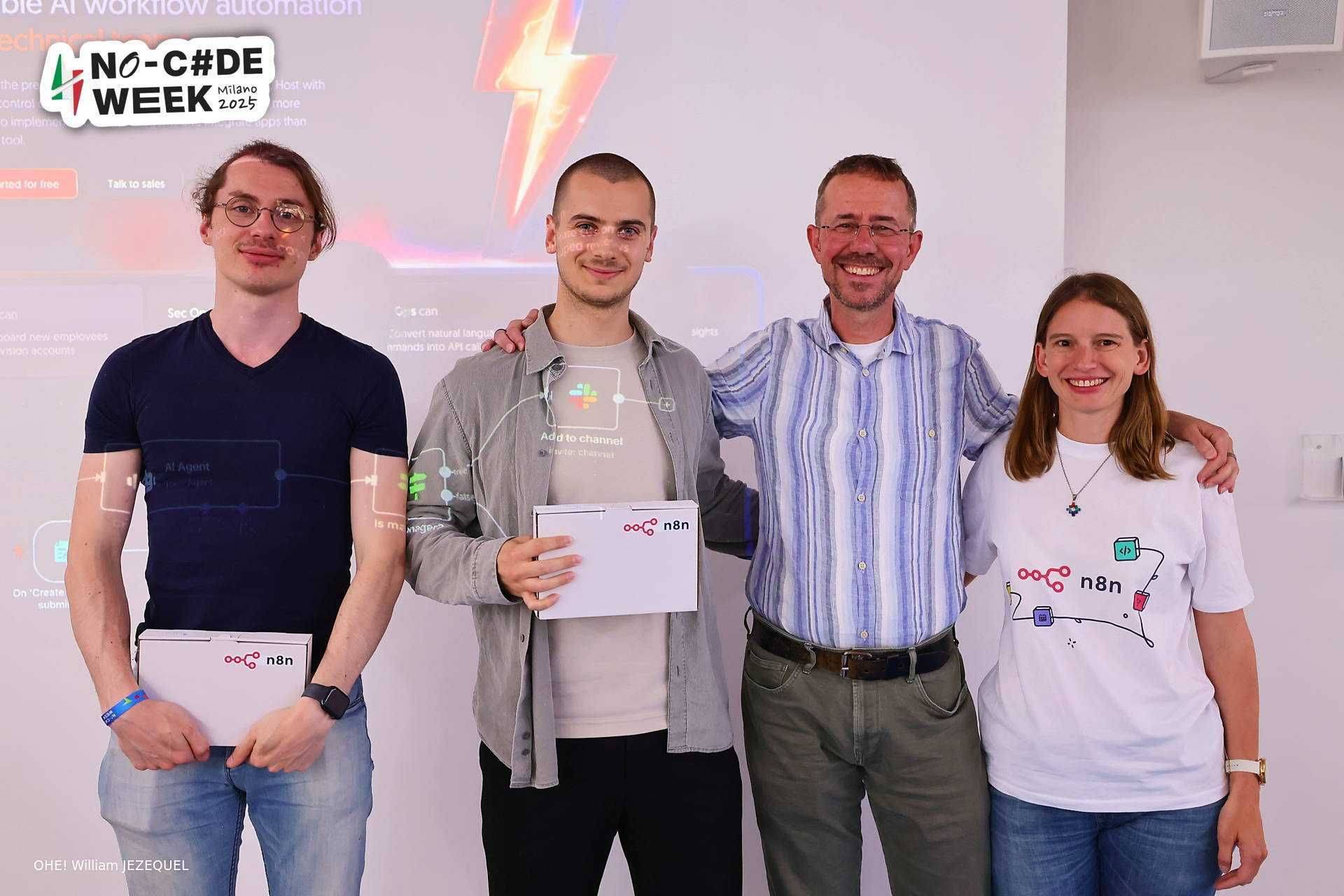Guillaume con los organizadores sosteniendo su premio del hackathon de n8n