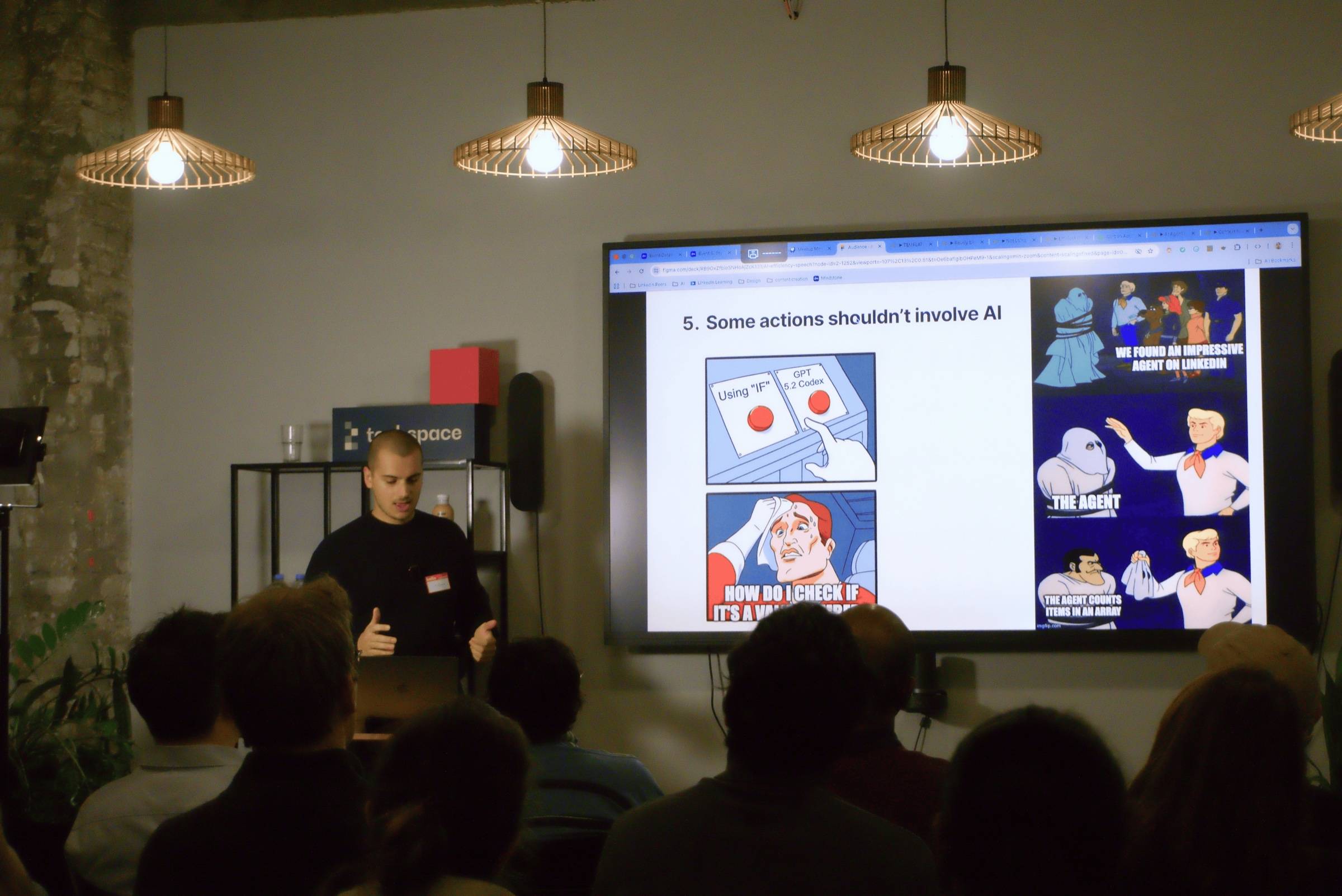 Guillaume haciendo una presentación sobre eficiencia de la IA, con una diapositiva detrás que dice "Some actions shouldn't involve AI"